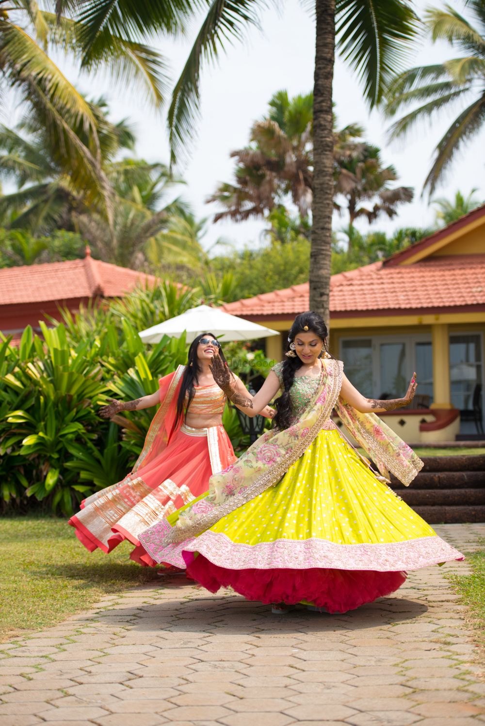 Photo of Twirling Bridesmaids in  Yellow and Pink Lehengas