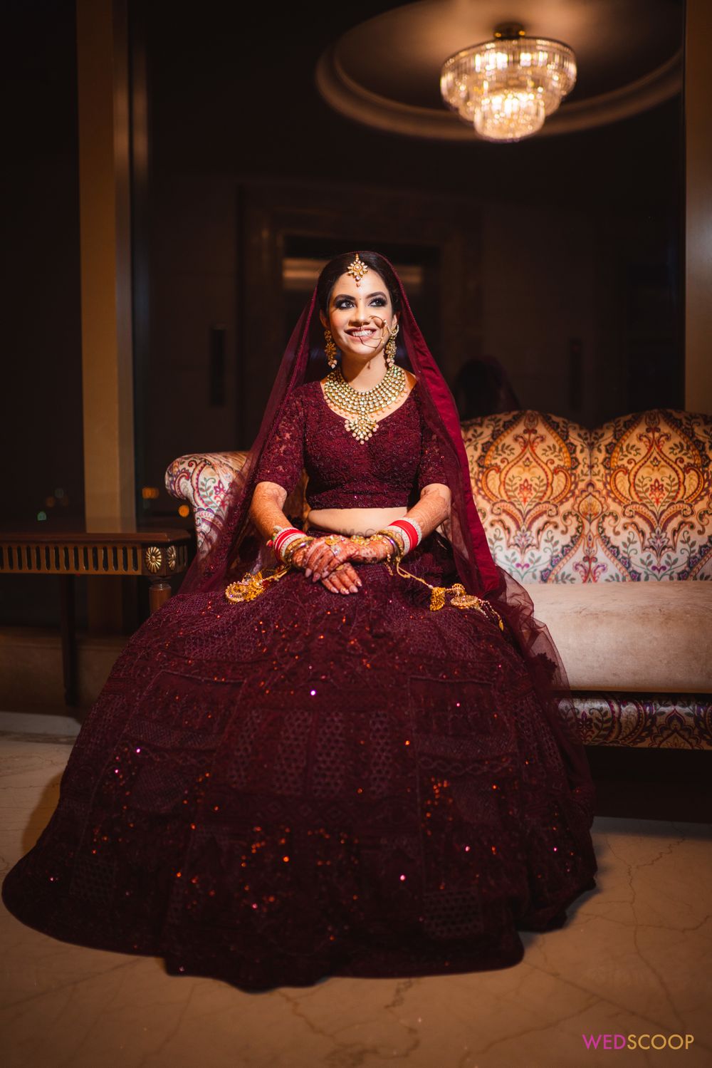Photo of Bride dressed in a deep maroon bridal lehenga.