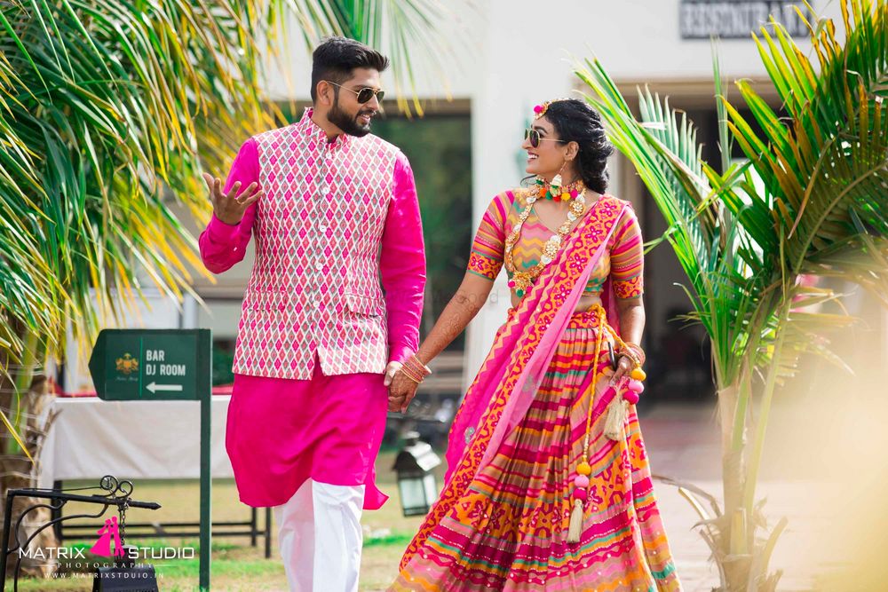 Photo of Coordinated bride and groom in pink for the mehendi