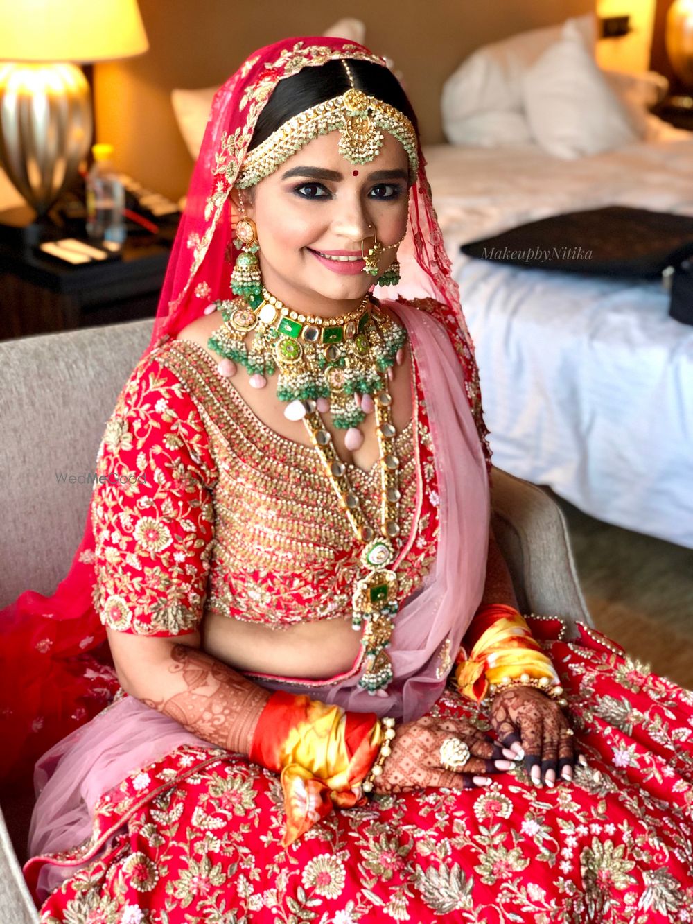 Photo of Bride wearing a red lehenga with contrasting jewellery.