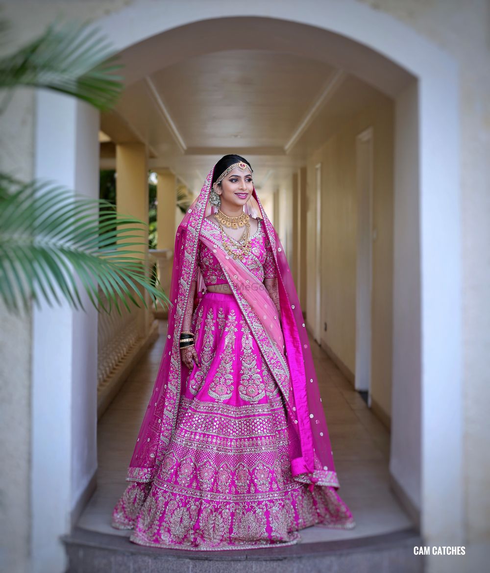 Photo of A bride in a rani pink lehenga for her wedding