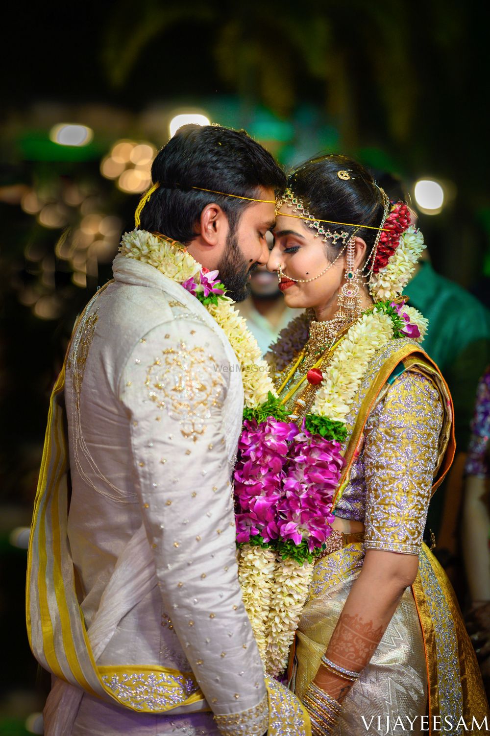 Photo of South Indian couple in colour-coordinated outfits on their wedding day