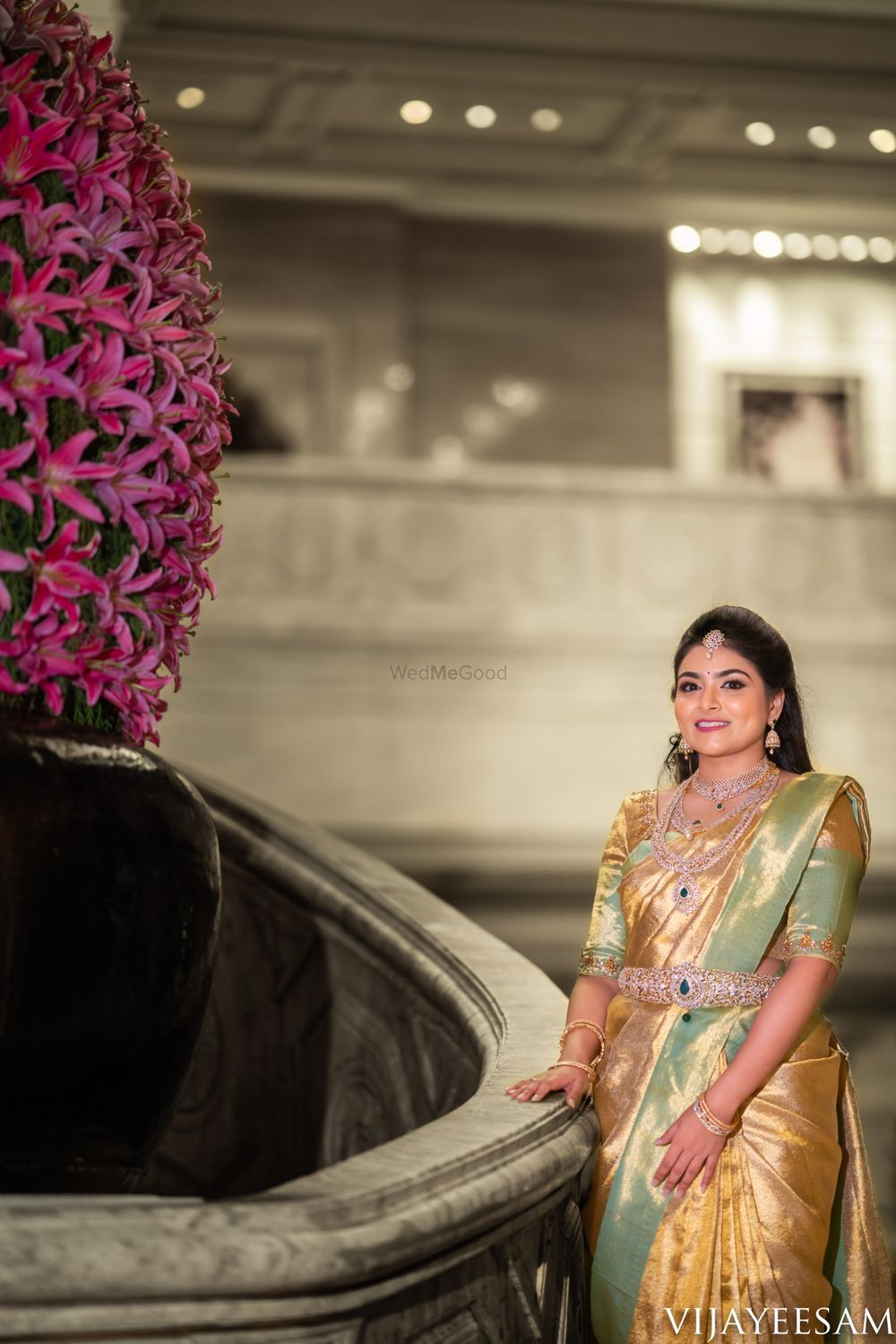 Photo of Bride in a gold and mint green saree with diamond jewellery.