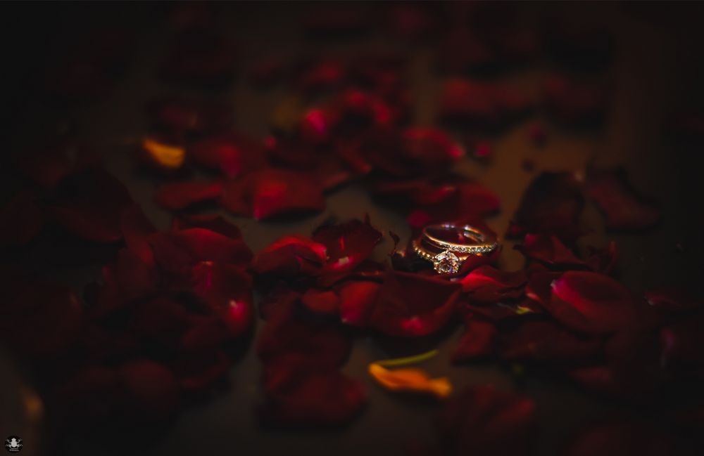 Photo of His and Her Engagement Rings with Rose Petals