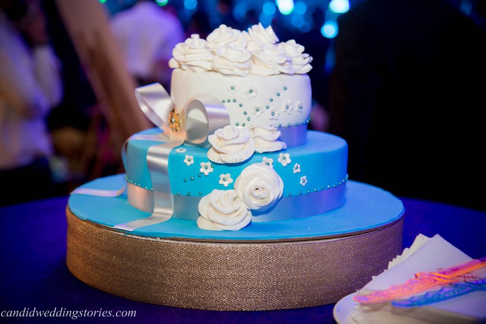 Photo of 3 Tier Blue and White Wedding Cake with Florals