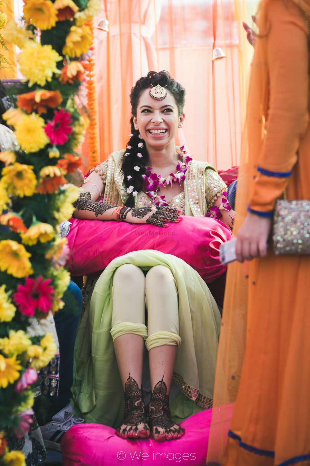 Photo of Bride Getting Mehendi Put Wearing Floral Jewellery