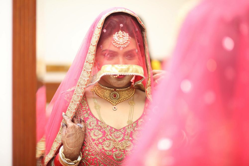 Photo of Bride Covering Face and Looking into Mirror