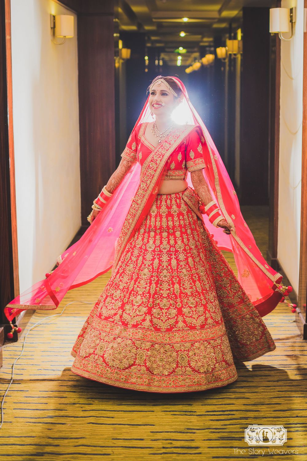 Photo of Bride Twirling in Bright Pink Lehenga with Gold Work