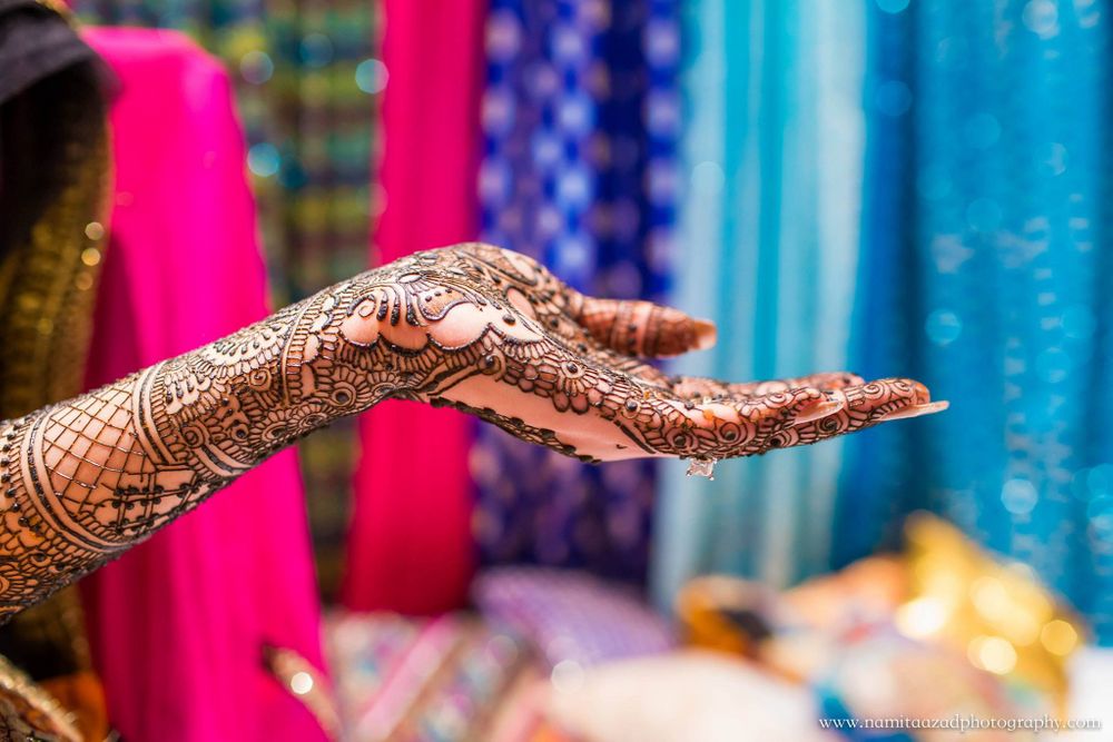 Photo of Mehendi Hand Against Blue and Pink Backdrop
