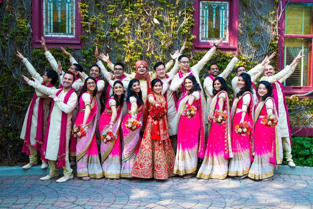Photo of Bridesmaids and Groomsmen in Pink Posing with Couple