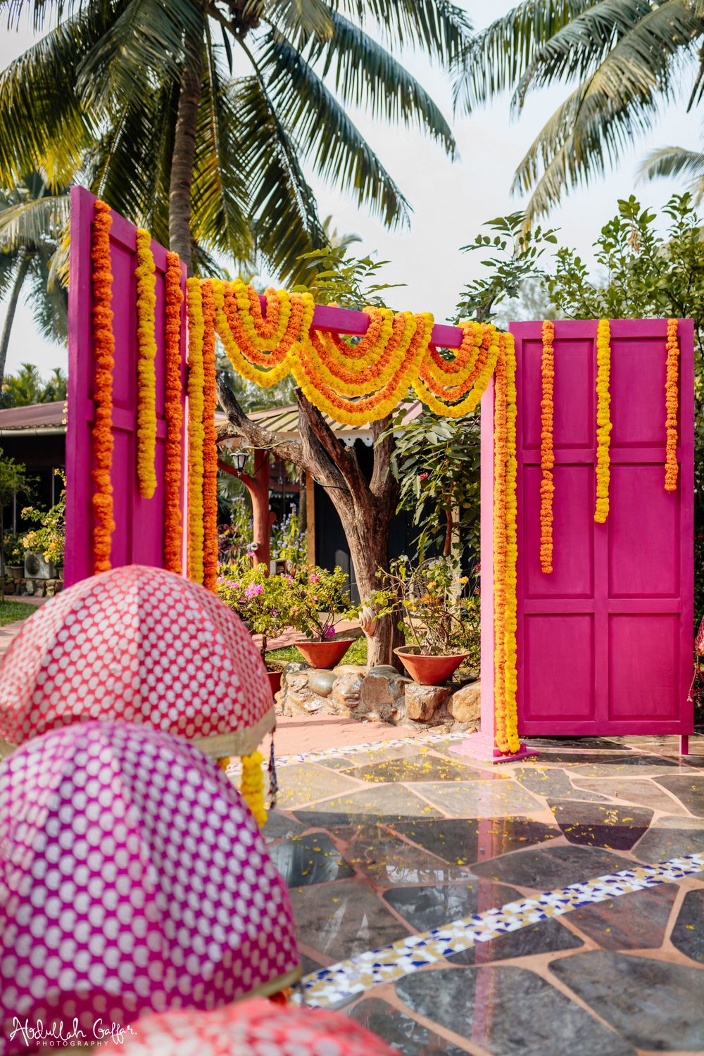Photo of Mehendi decor with a pink entrance and genda phools.