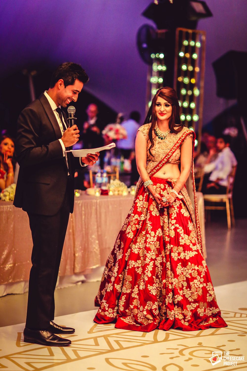 Photo of Groom Reading Out Vows to Bride in Red and Gold Lehenga