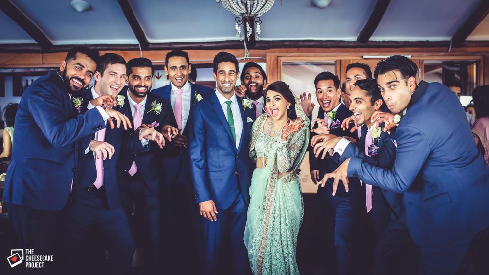 Photo of Bride and Groom Posing with Matching Groomsmen