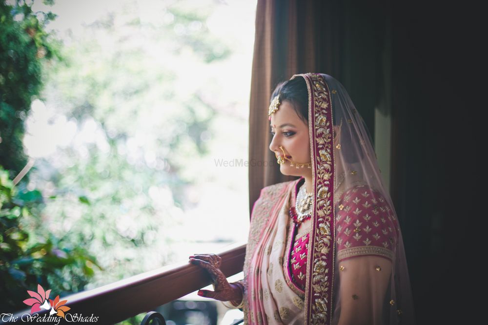 Photo of Bride in Shades of Pink Looking out of Window