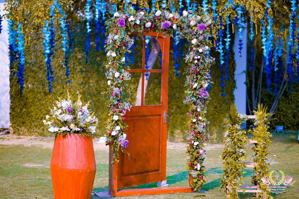 Photo of Photobooth with a wooden door frame and a drum decorated with flowers.