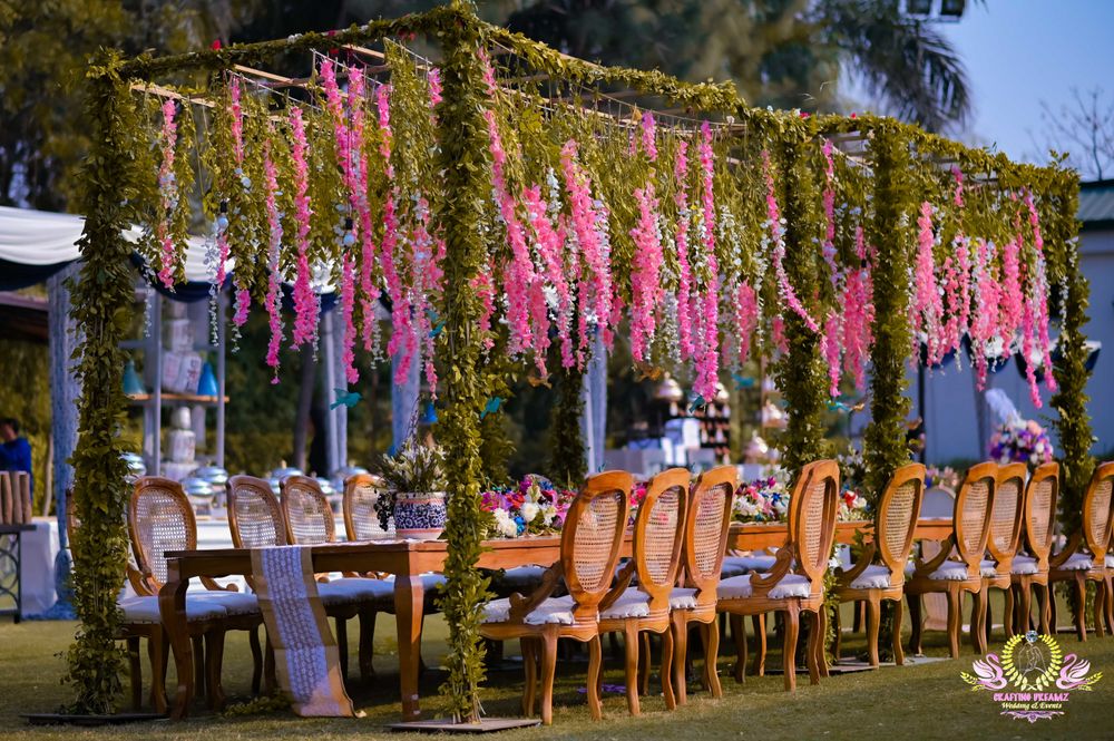 Photo of Outdoor dinner table seating with floral ceilings.