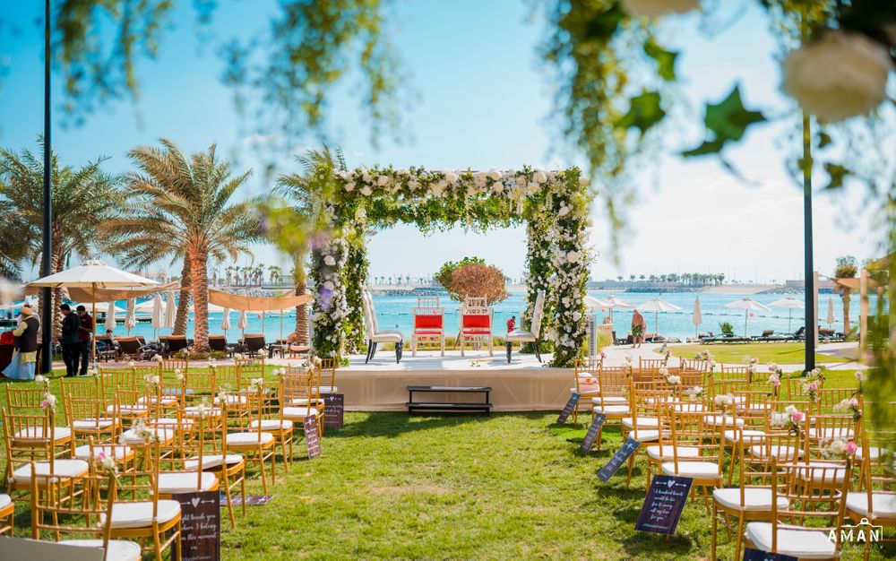 Photo of beachside white floral mandap with chair arrangement
