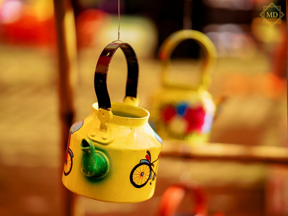 Photo of Hanging hand-painted kettles in mehndi decor.
