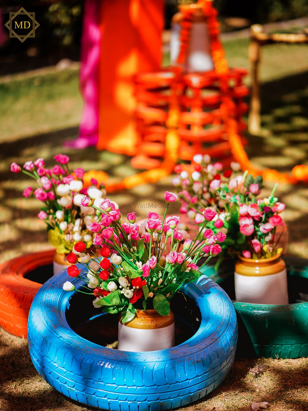 Photo of Tyres and flowers filled in mason jars used for Mehendi decor.
