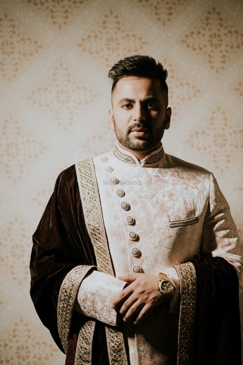 Photo of off white and gold groom sherwani with asymmetric buttons
