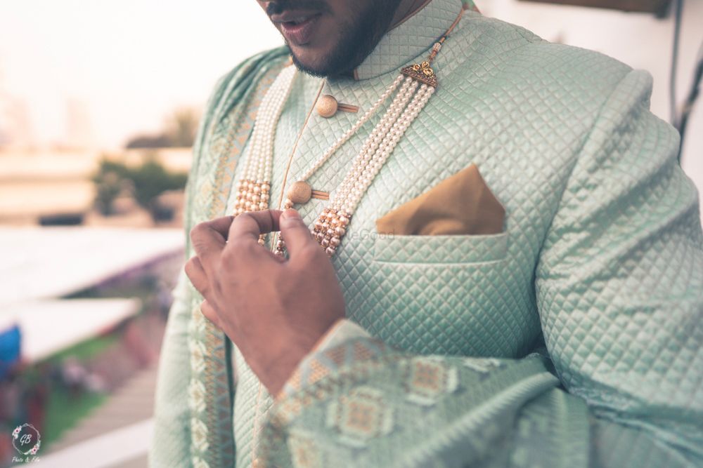 Photo of offbeat groom sherwani with pearl necklace