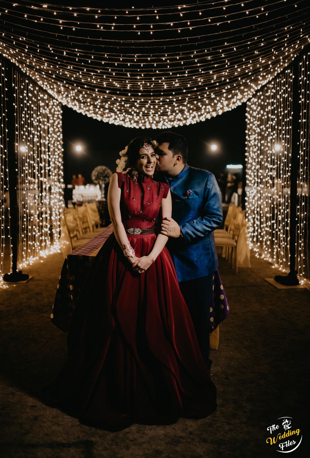 Photo of A cute couple portrait with fairy lights in the backdrop.