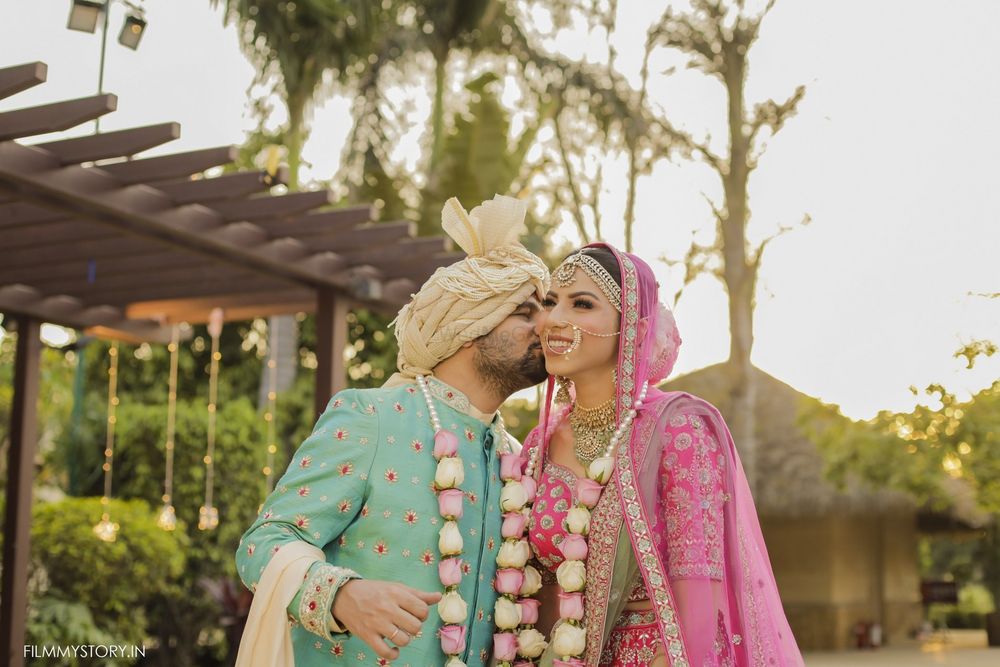 Photo of contrasting bride and groom in turquoise and bright pink