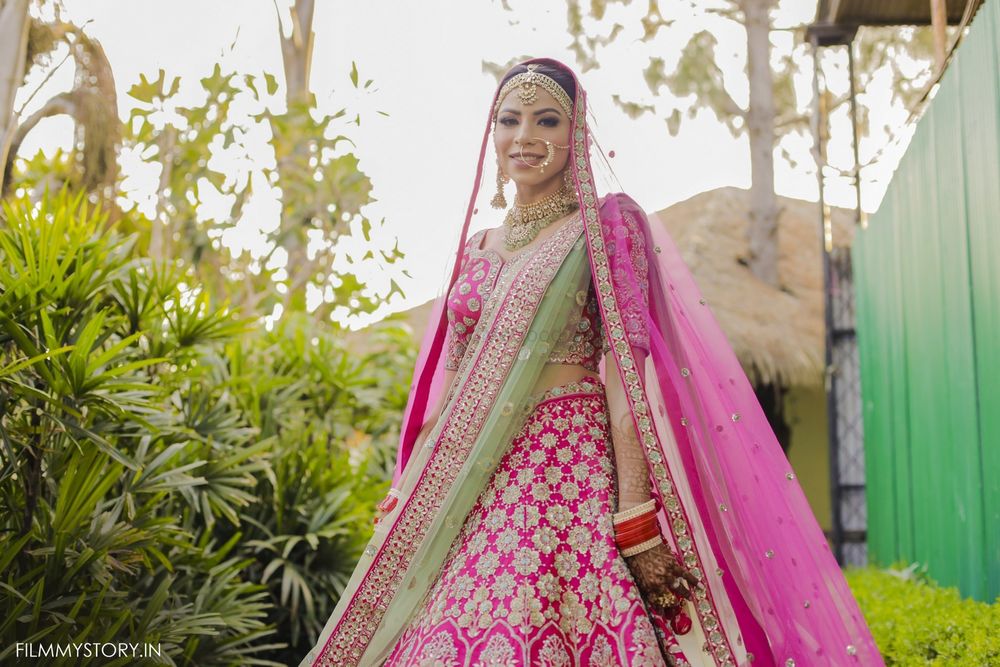 Photo of bright pink lehenga with contrasting green dupatta
