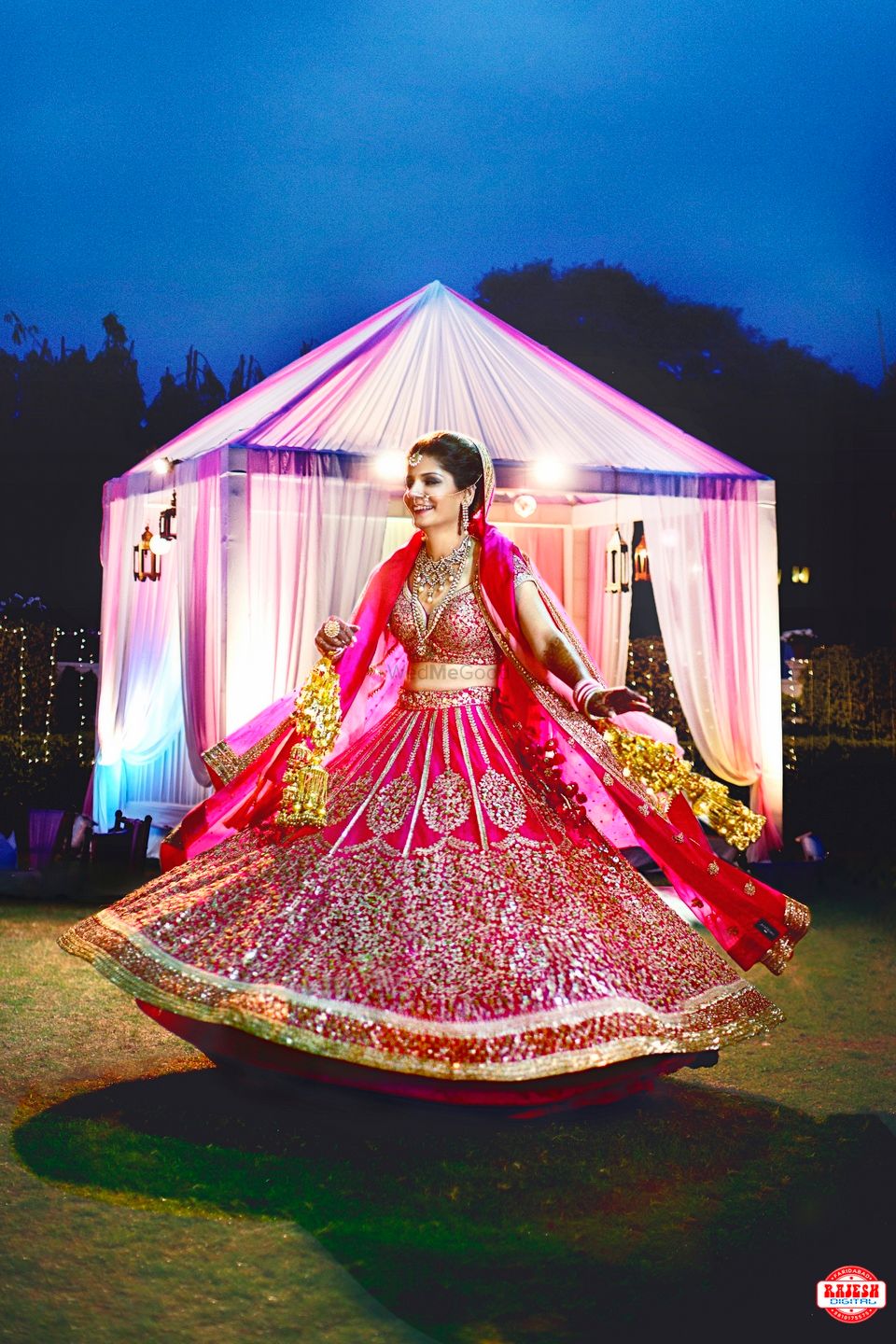 Photo of Bride Twirling in Deep Pink and Gold Wedding Lehenga
