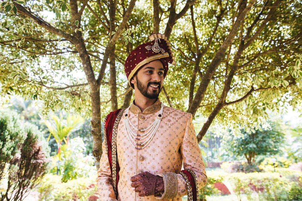 Photo of light pink and maroon groom sherwani