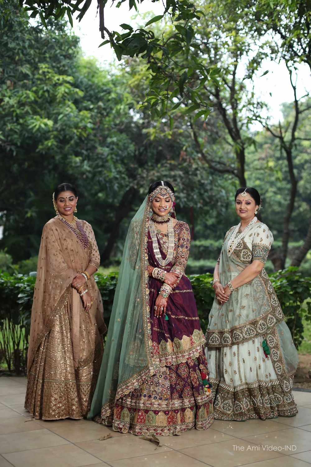 Photo of bride in unique lehenga with mother and her sister