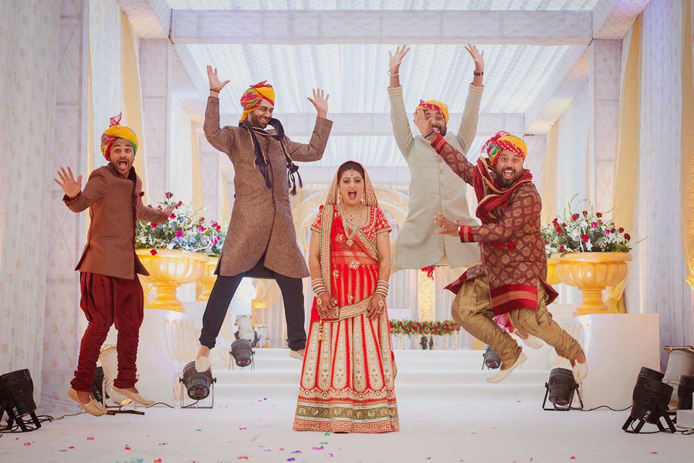 Photo of Bride with Jumping Groomsmen
