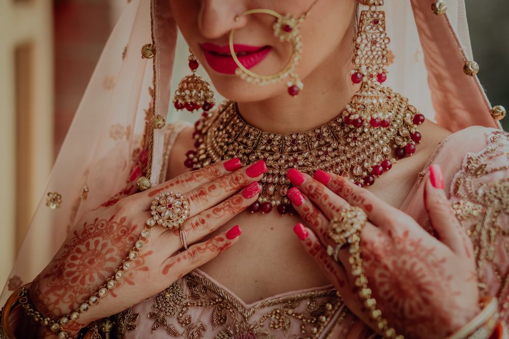 Photo of pastel lehenga with maroon jewellery close up shot