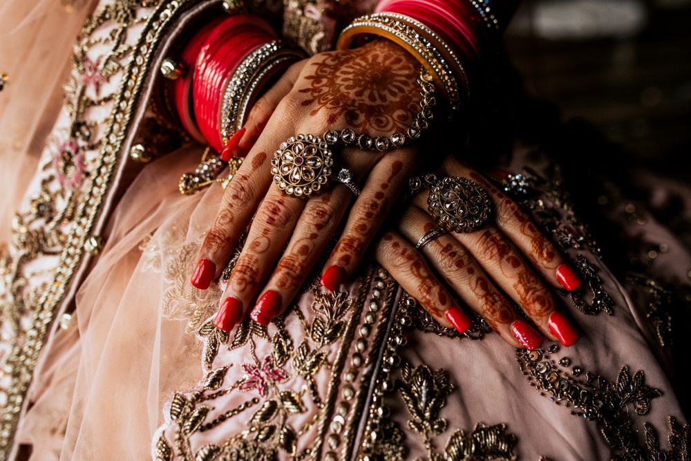 Photo of pretty bridal hands on pastel lehenga with haathphool