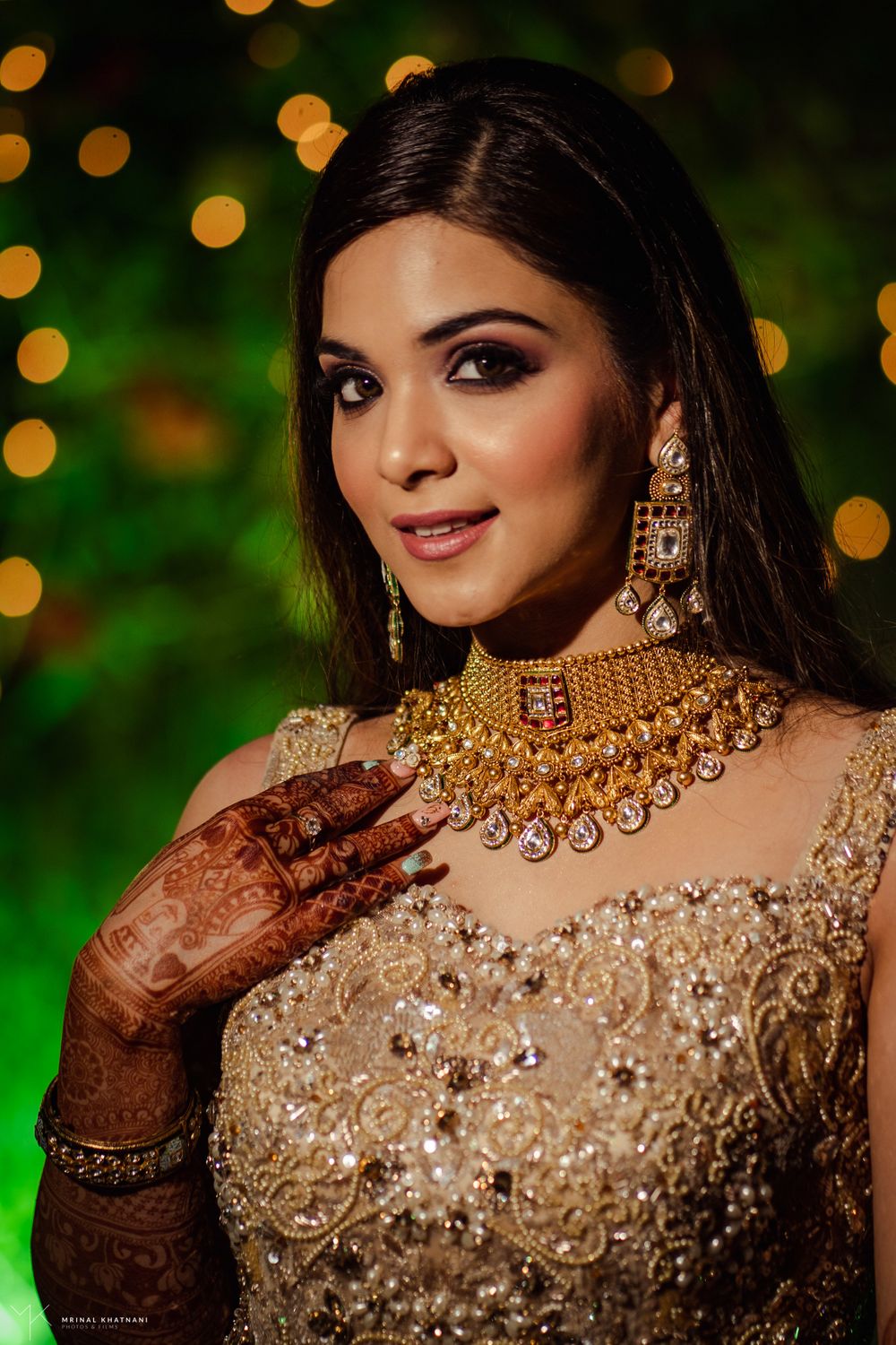 Photo of Bride wearing a gold necklace with a gold gown.