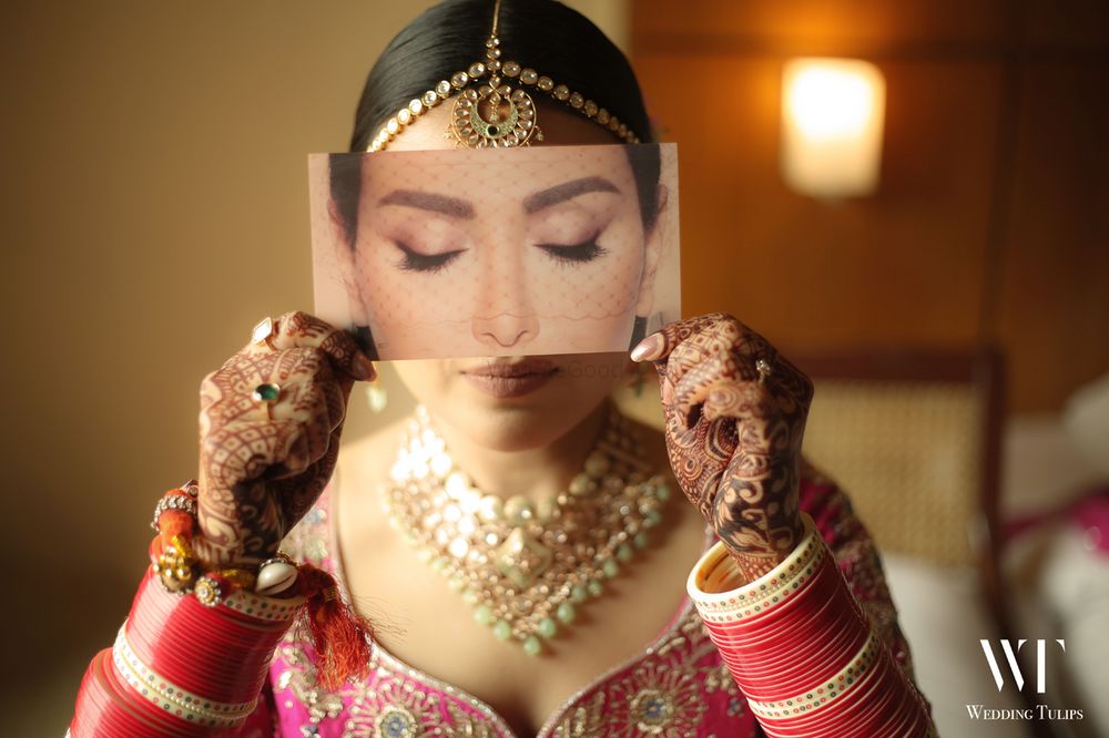 Photo of bridal makeup portrait with bride holding eye palette