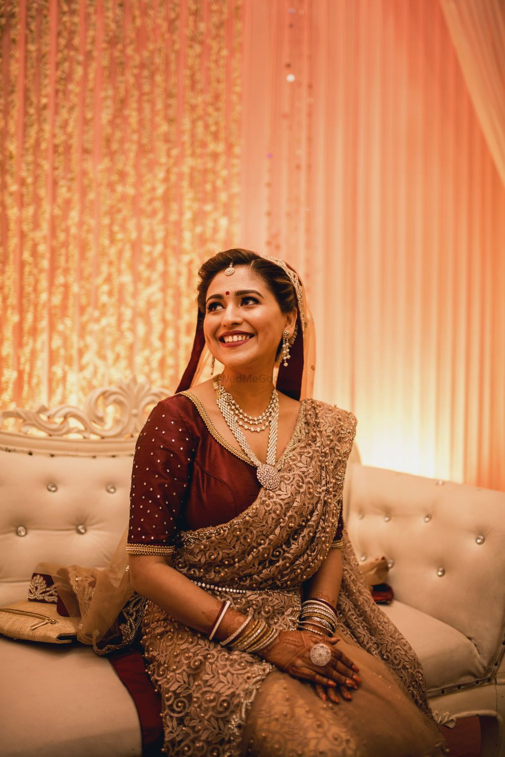 Photo of Bride wearing a deep maroon blouse with beige saree.