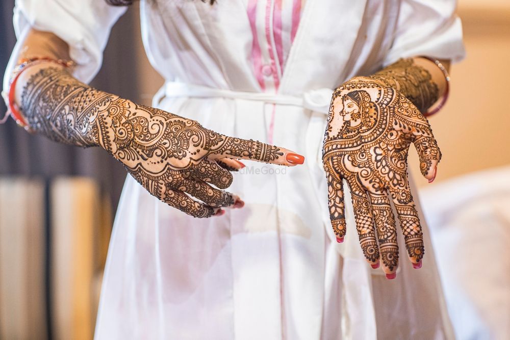 Photo of bride showing her portrait mehendi on one hand