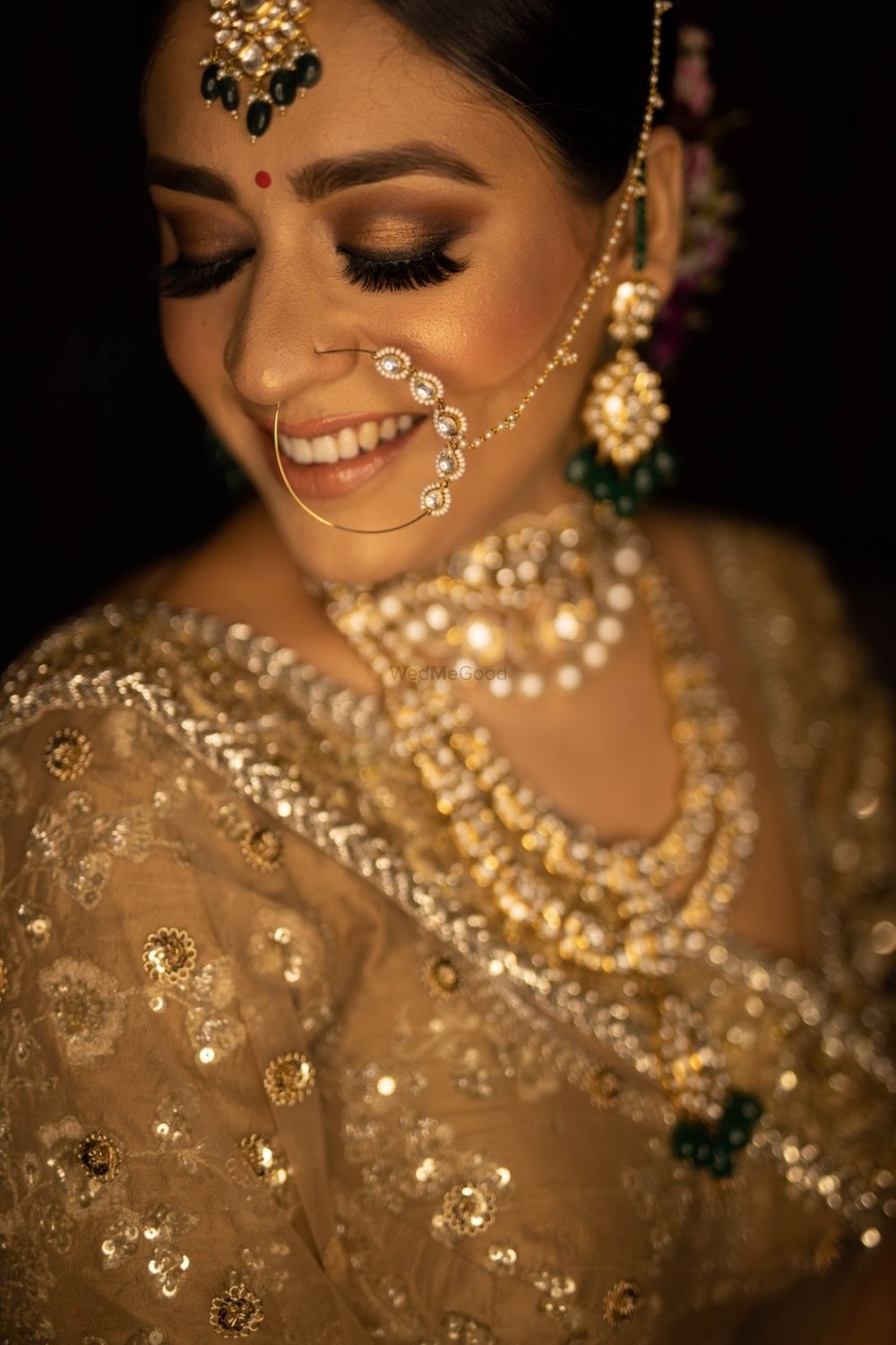 Photo of subtle bridal makeup with nude lip and gold lehenga