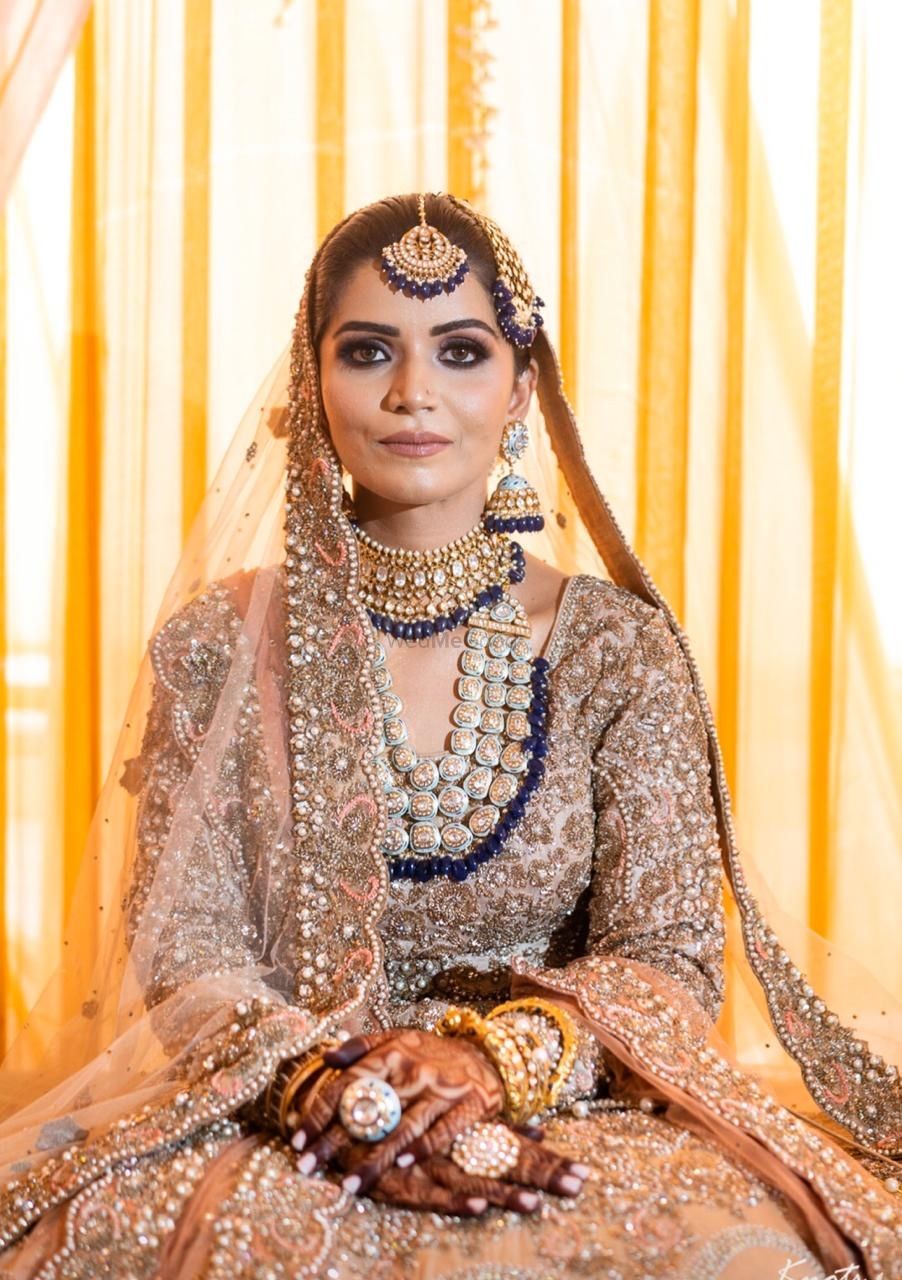 Photo of Candid shot of a bride dressed in a heavy lehenga.