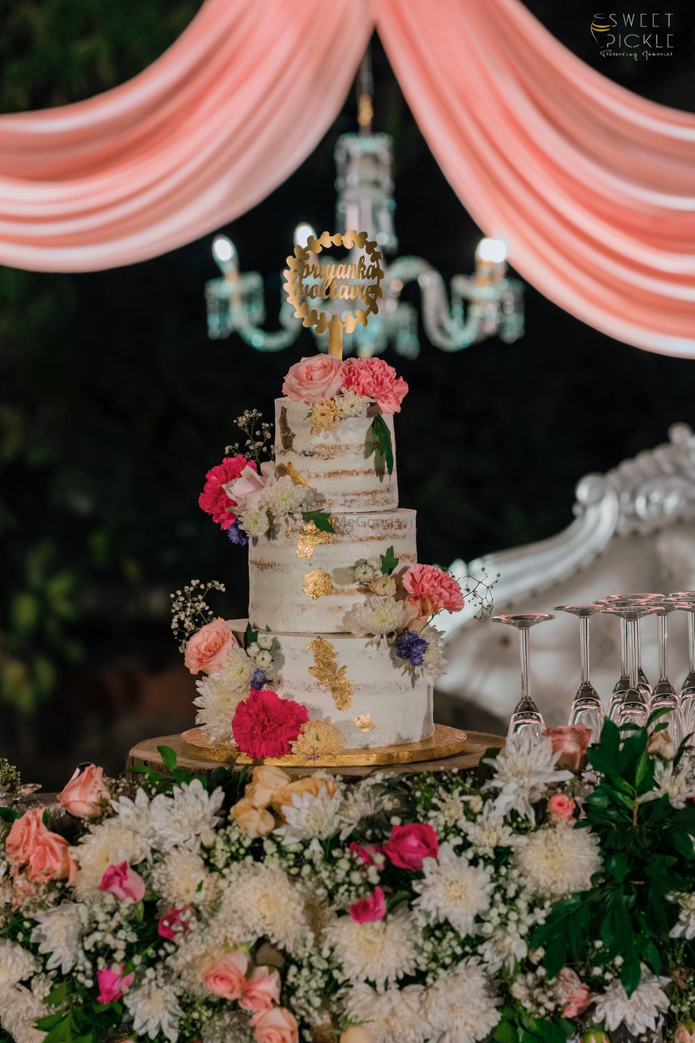 Photo of Three-tier wedding cake with flowers.