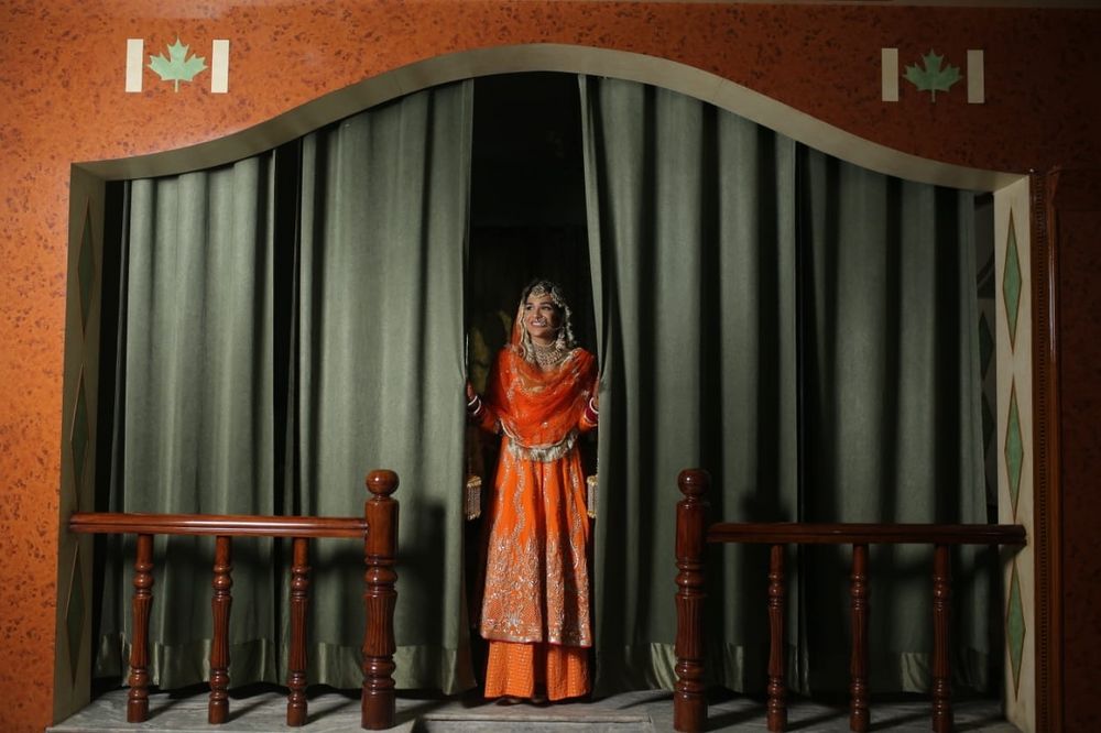 Photo of Bride in an orange suit with flared pants
