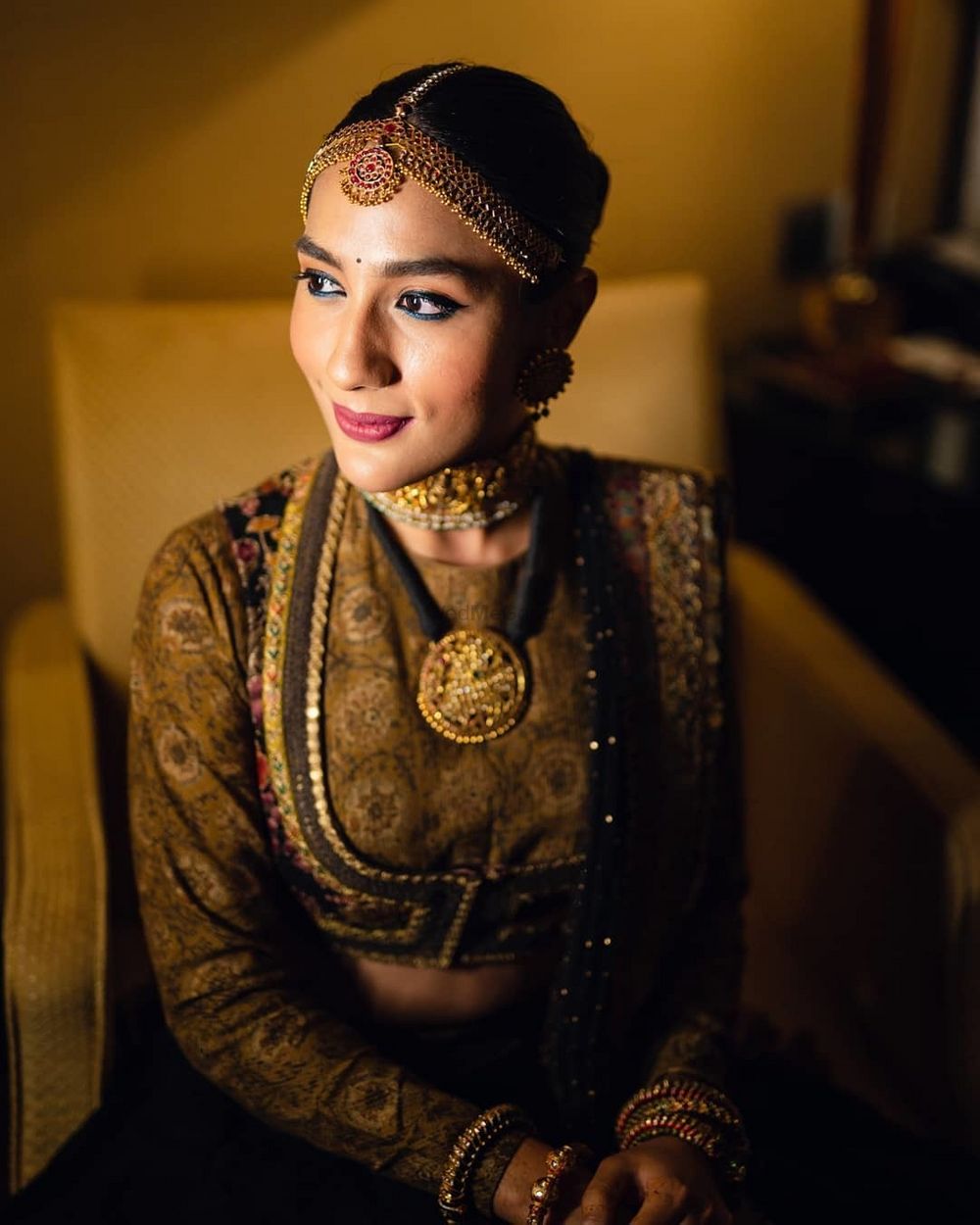 Photo of Bride wearing a jacket style blouse with her lehenga.