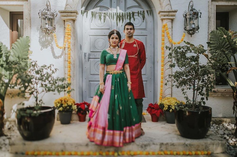 Photo of Bride and groom color-contrasting in green and red.