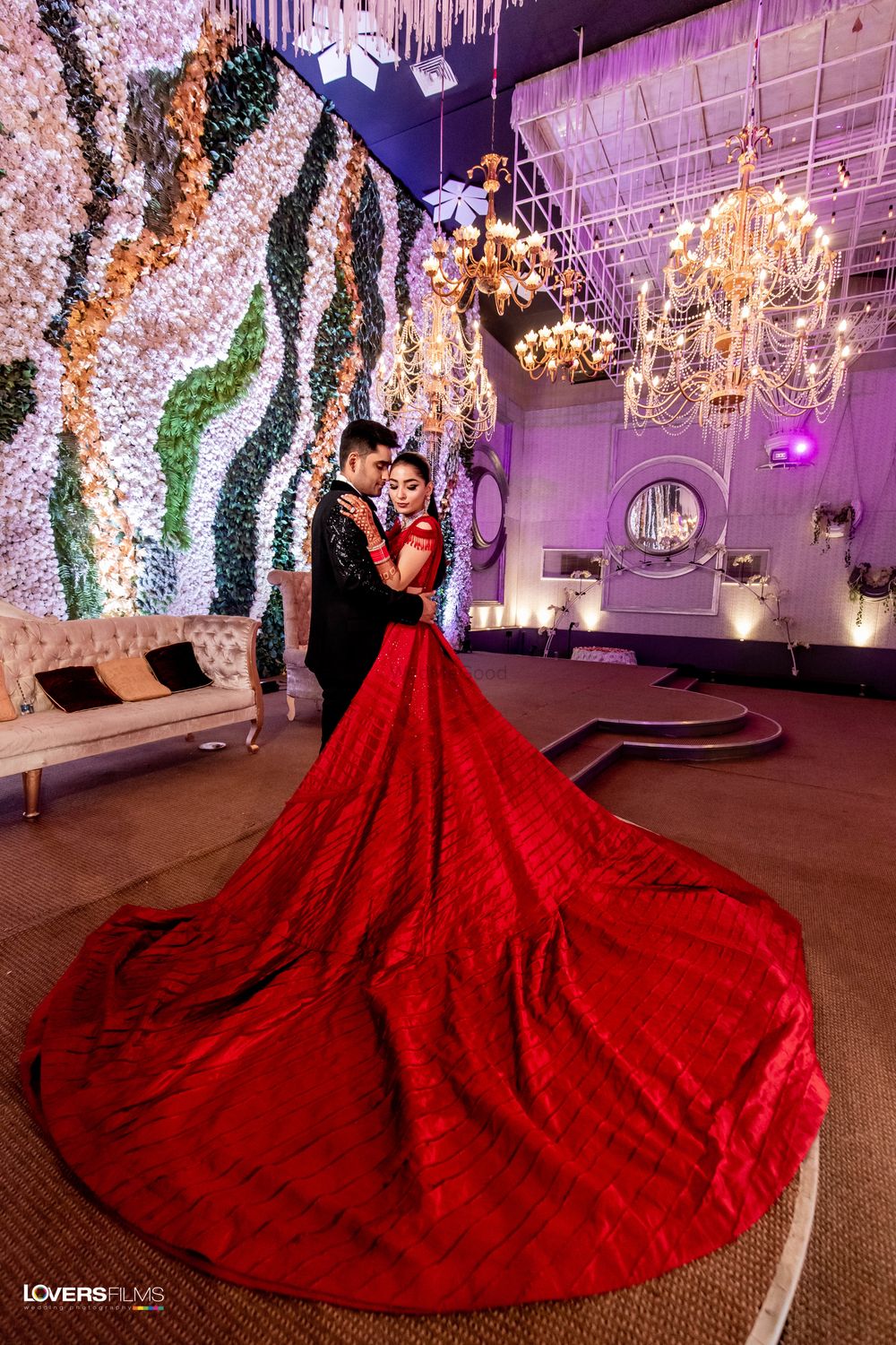 Photo of red gaurav gupta gown with a long train