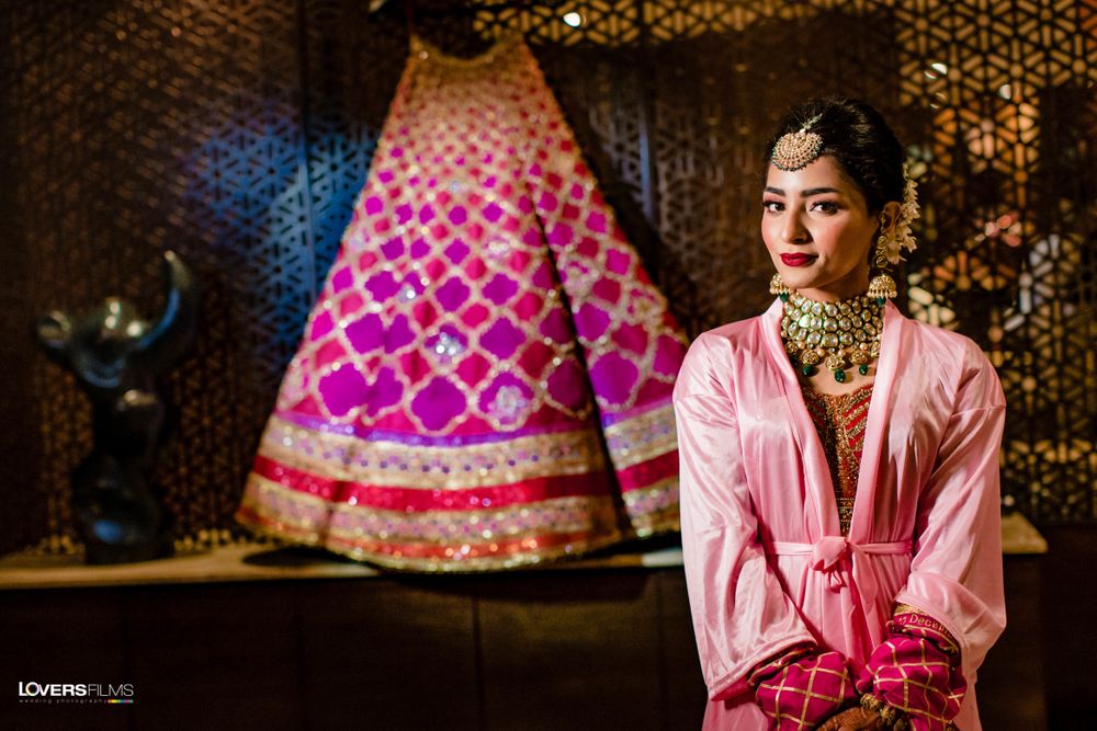 Photo of bride in her robe with her lehenga on hanger