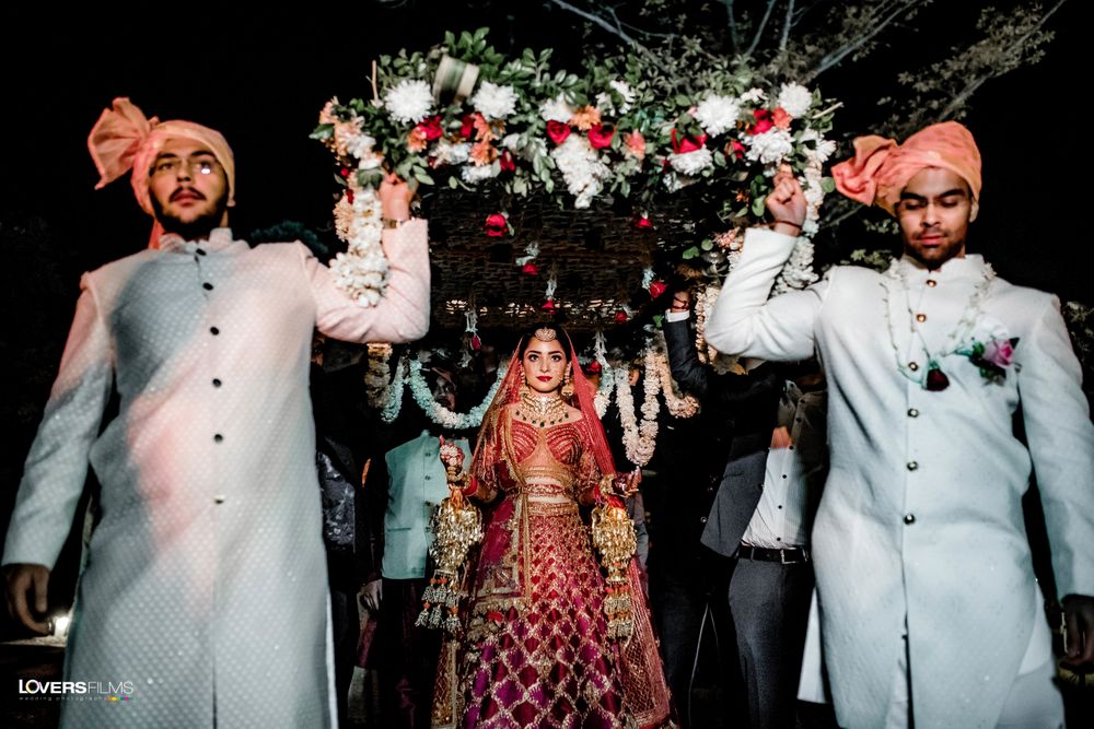 Photo of bride entering under chaddar with matching bridesmen