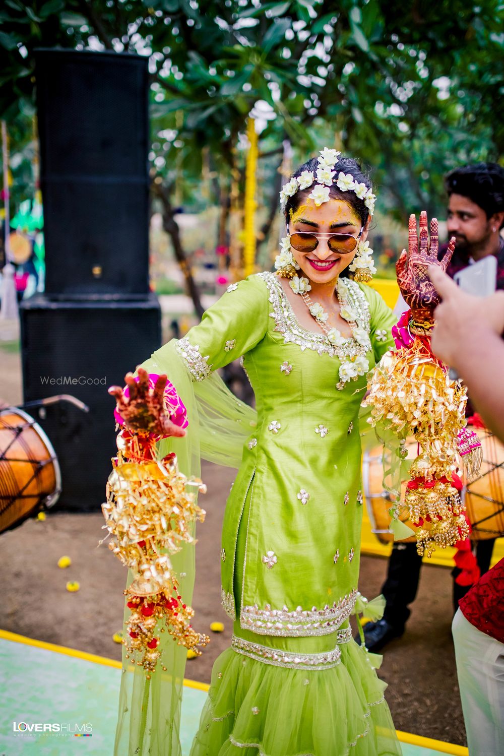 Photo of mehendi bridal look in lime green sharara and floral jewellery