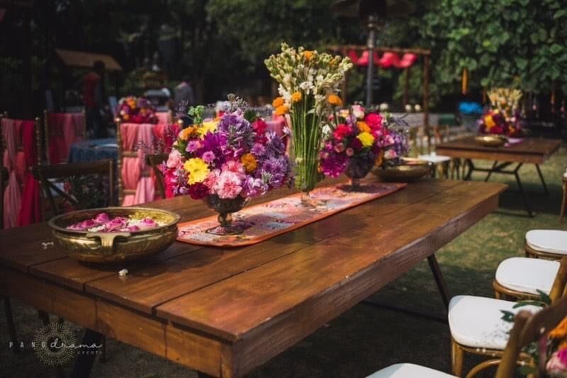 Photo of table setting for backyard mehendi on rustic table
