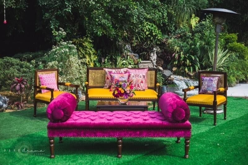Photo of funky decor elements for mehendi with a fuchsia sofa